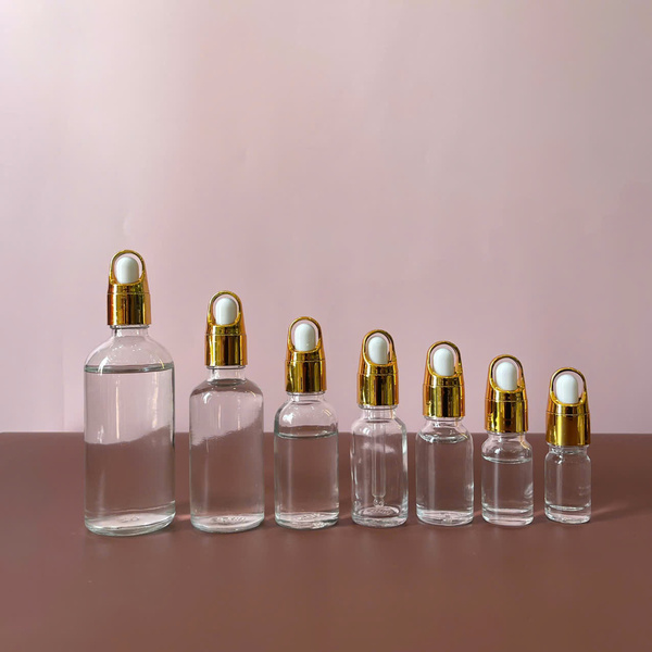 Chai serum trong khoen quai xách vàng nút trắng